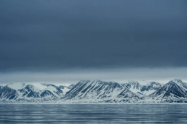 蓝色时间的全景 斯瓦尔巴群岛的风景 伴随着大海 群山和壮观的天空 漆黑平静的大海 白雪覆盖着群山和漆黑的天空 高质量的照片 — 图库照片