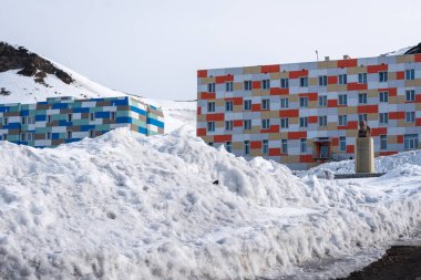 Rus şehri Barentsburg 'un Spitsbergen takımadaları üzerindeki manzarası kışın kutuplarda güneşli havada ve bulutlu gökyüzünde.