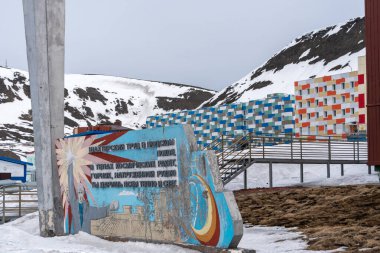 Rus şehri Barentsburg 'un Spitsbergen takımadaları üzerindeki manzarası kışın kutuplarda güneşli havada ve bulutlu gökyüzünde.