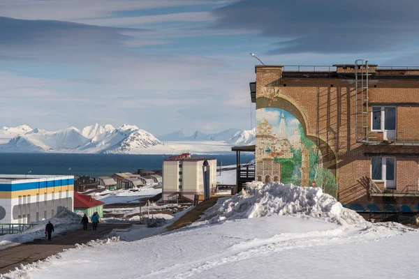 Rus şehri Barentsburg 'un Spitsbergen takımadaları üzerindeki manzarası kışın kutuplarda güneşli havada ve bulutlu gökyüzünde.