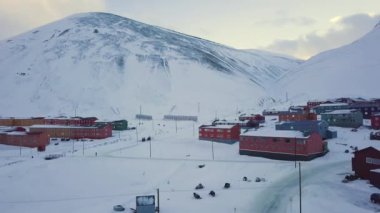 Aerial view of Longyearbyen, Svalbard in winter. With colorful houses, snow-capped mountains and with avalanche protection. High quality 4k footage