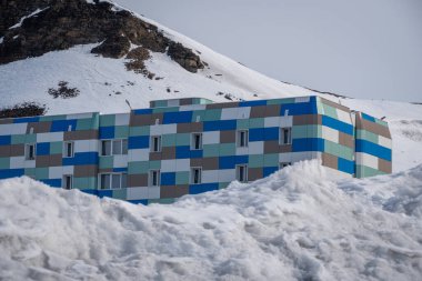 Rus şehri Barentsburg 'un Spitsbergen takımadaları üzerindeki manzarası kışın kutuplarda güneşli havada ve bulutlu gökyüzünde.