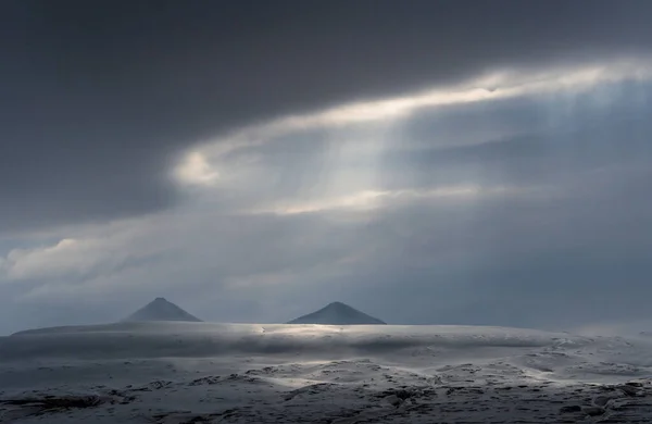 Panoramic view of Blue hour. Landscape of the Svalbard archipelago, with the Sea, mountains and dramatic sky. Dark calm sea, snow covered mountains and dark skies. High quality photo