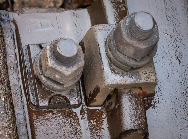 Railway track bolts. Detail of rusty screws and nut on railroad track. High quality photo