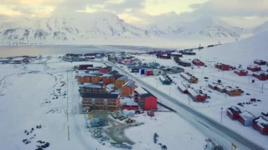 Longyearbyen 'in havadan görünüşü, Svalbard' ın kışın. Renkli evler, karla kaplı dağlar, çığ koruması ve fiyort ile. İHA uçuşu. Yüksek kalite 4k görüntü