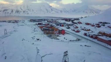 Longyearbyen 'in havadan görünüşü, Svalbard' ın kışın. Renkli evler, karla kaplı dağlar, çığ koruması ve fiyort ile. İHA uçuşu. Yüksek kalite 4k görüntü