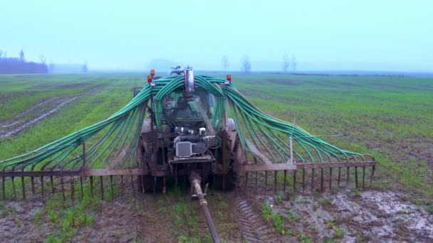トラクターは畑を通って農業用肥料を放出した 農業の秋の仕事 ドローン映像 — ストック動画