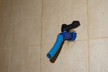 Plastikten yapılmış mavi su musluğu banyoda.