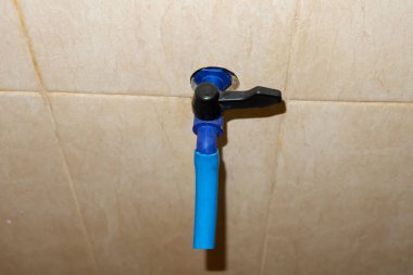 Plastikten yapılmış mavi su musluğu banyoda.