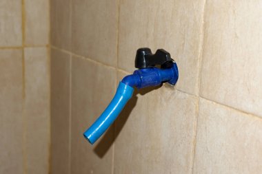 Plastikten yapılmış mavi su musluğu banyoda.