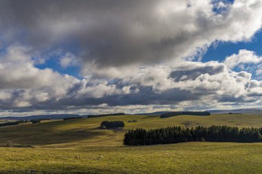 Bulutlu ve güneşli gökyüzü Aubrac ile Tepelerin Üzerindeki Işıklar ve Gölgeler