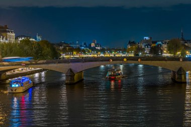 Paris 'teki Seine Nehri üzerindeki tarihi köprü Gece Tekneleri Mimari Seyahatleri Mimari Işıklar Yansımaları