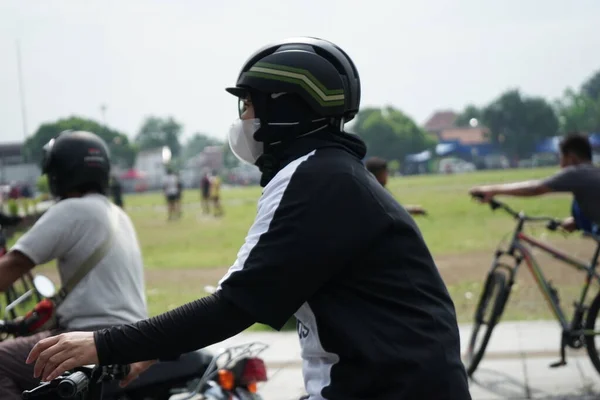 man in protective helmet and black gloves riding on the road