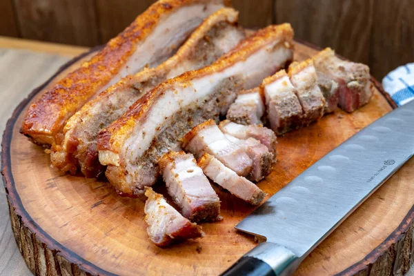 Crispy Pork Belly Roast, Hong Kong and Asian Style, Whole and Chopped. This type of roast pork is famous for having a crunchy skin texture while the meat remains soft with a blend of fat
