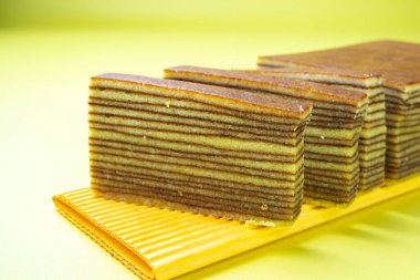 Yasal katlı pasta ya da spekuk katlı pasta, katmanlı yumuşak desenli pasta. biraz pürüzlü sarı arkaplanlı desenli