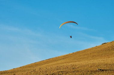 Mavi gökyüzüne karşı yamaç paraşütü