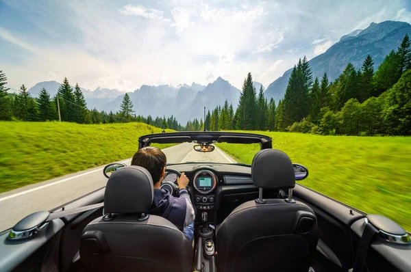Drivers hands on a steering wheel of a convertible car. Road trip on the Italians road. Fotografia De Stock