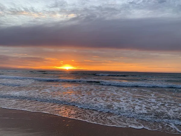 Sahile vuran gün doğumu - bulutlar arasından ışınlar