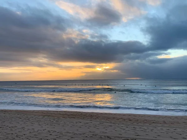Sahile vuran gün doğumu - bulutlar arasından ışınlar