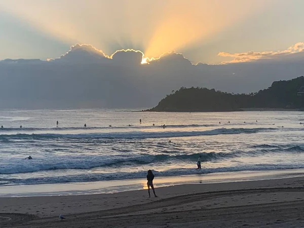Sahile vuran gün doğumu - bulutlar arasından ışınlar