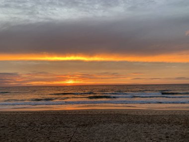 Altın okyanus gün doğumu, fırtınalı bulutlar