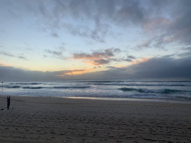 Fırtınalı okyanusta gri gün doğumu