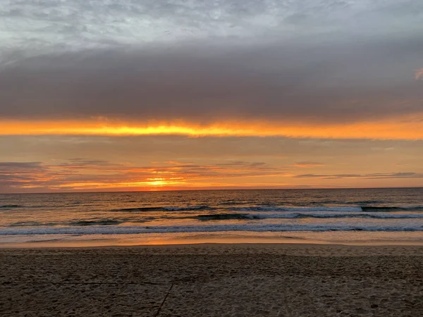 Altın okyanus gün doğumu, fırtınalı bulutlar