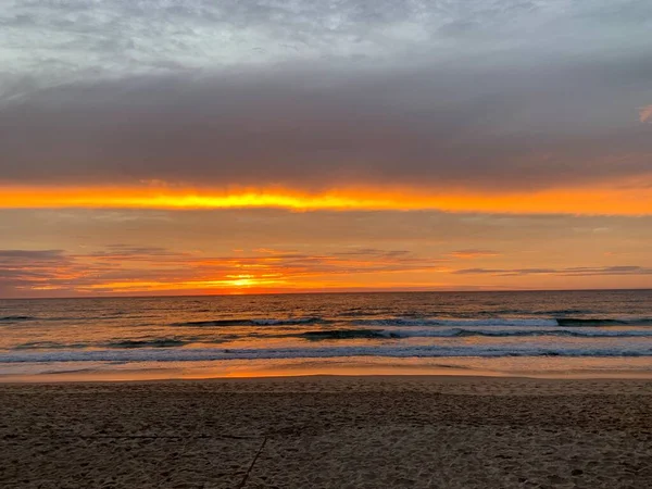 Okyanusun üzerinde çarpıcı turuncu gün doğumu