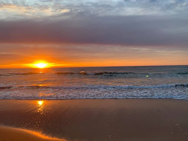 Okyanusun üzerinde koyu turuncu gün doğumu