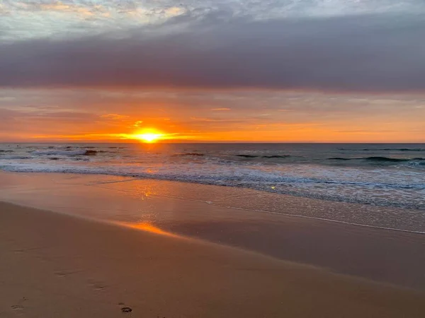 Okyanusun üzerinde koyu turuncu gün doğumu
