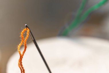 Simple needle and thread close -up. Textile. Needlework. Macro shooting thread in a needle.