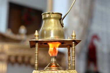 Türk kahvesi, bakır el yapımı Türk kahve makinesinde kahvaltıyla içmek, rahatlamak ve mola vermek için hazırlanıyor. Sabah rutini, bulanık arka plan.