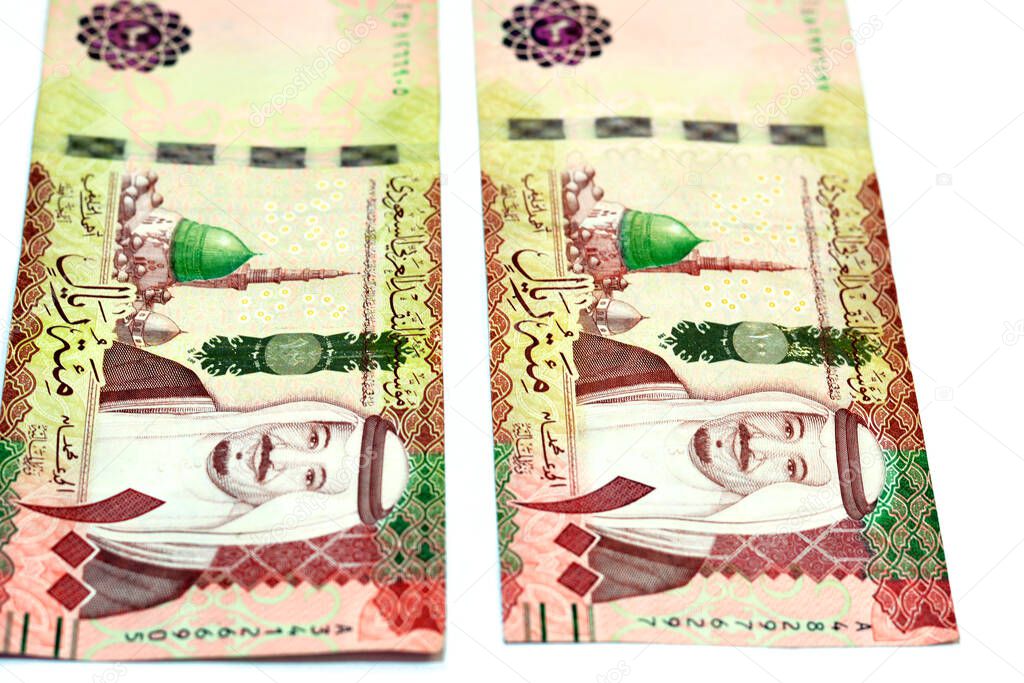 Obverse side of 100 one hundred Saudi riyals banknotes features prophet's mosque in Medina  and portrait of king Salman Bin AbdelAziz Al Saud, Saudi Arabia currency isolated on white background