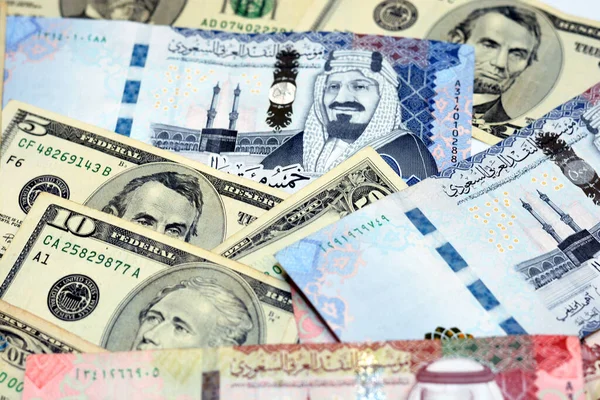 一堆堆具有美利坚合众国背景的沙特阿拉伯里亚尔钞票 一组有选择的沙特阿拉伯里亚尔钞票和美元钞票汇率 — 图库照片