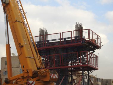 Mısır 'ın inşaat sahasında çelik ve beton dairesel kolonlar, yapı iskelesi ve bir vinç ile tek hat demiryolu taşıma sistemi üzerinde yükseltilmiş iki ray var.