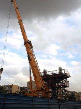 Mısır 'ın inşaat sahasında çelik ve beton dairesel kolonlar, yapı iskelesi ve bir vinç ile tek hat demiryolu taşıma sistemi üzerinde yükseltilmiş iki ray var.