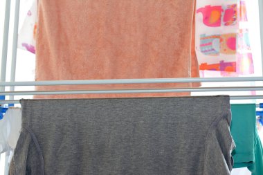 Giysilerin ve çamaşırların seçici odak noktası plastik çok katmanlı bir elbise askısı askısı kurutma askısı, çamaşır ve ev ödevi ve hijyen konsepti, çamaşır atında yıkandıktan sonra temiz giysilerin kurutulması.