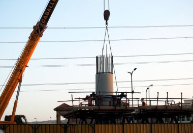 Giza, Mısır, 9 Aralık 2021: Mısır inşaat sahasında işçiler tek raylı taşıma sisteminde çelik parçaları bir vinç tarafından Giza demiryolunun çelik ve beton sütununa monte edip monte ediyorlar.