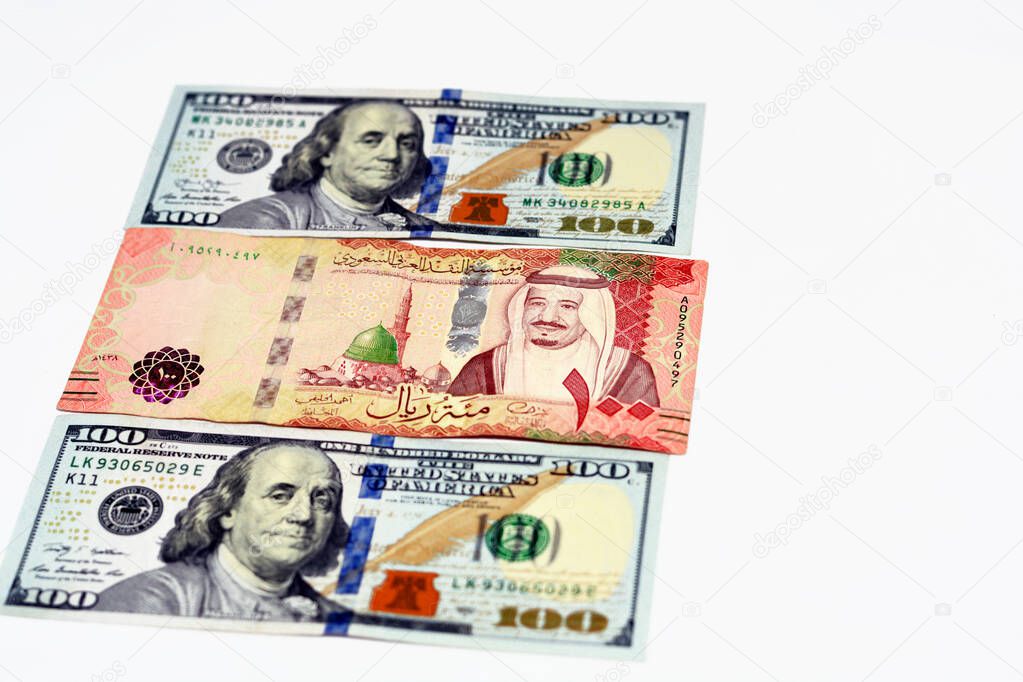 billete-de-cien-d-lares-estadounidenses-y-riales-de-arabia-saudita