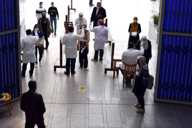 Bina girişinden önce katı önlemler, yüz maskeleri, el jelleri, temassız kızılötesi termometre ile sıcaklık taraması ve koronavirüs küresel kriz salgınının ortasında covid-19 yayılmasını önlemeye çalışan sosyal mesafeler