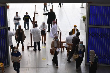 Bina girişinden önce katı önlemler, yüz maskeleri, el jelleri, temassız kızılötesi termometre ile sıcaklık taraması ve koronavirüs küresel kriz salgınının ortasında covid-19 yayılmasını önlemeye çalışan sosyal mesafeler