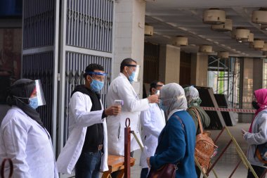 Mısır 'da sıkı koronavirüs önlemleri altında üniversite binasına giriş, covid-19 virüsünün yayılmasına karşı ihtiyati tedbirler, temas olmayan kızılötesi termometre, sosyal uzaklık ve yüz maskeleri takarak sıcaklığı kontrol etme