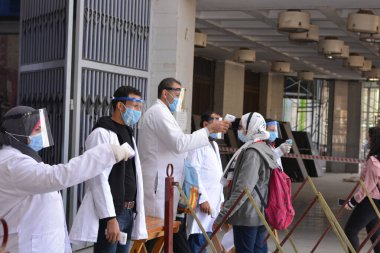 Mısır 'da sıkı koronavirüs önlemleri altında üniversite binasına giriş, covid-19 virüsünün yayılmasına karşı ihtiyati tedbirler, temas olmayan kızılötesi termometre, sosyal uzaklık ve yüz maskeleri takarak sıcaklığı kontrol etme