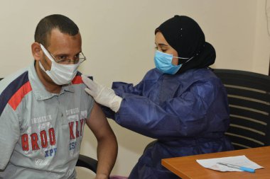 Kahire, Mısır. 31 Ağustos 2021: Kişiye koronavirüs aşısı, COVID-2019 aşısı, salgın hastalığa karşı aşı, Coronavirus aşısı, Covid-19 aşısı, virüsü kontrol altına almak için