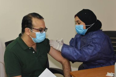 Kahire, Mısır. 31 Ağustos 2021: Kişiye koronavirüs aşısı, COVID-2019 aşısı, salgın hastalığa karşı aşı, Coronavirus aşısı, Covid-19 aşısı, virüsü kontrol altına almak için