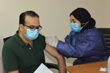 Kahire, Mısır. 31 Ağustos 2021: Kişiye koronavirüs aşısı, COVID-2019 aşısı, salgın hastalığa karşı aşı, Coronavirus aşısı, Covid-19 aşısı, virüsü kontrol altına almak için