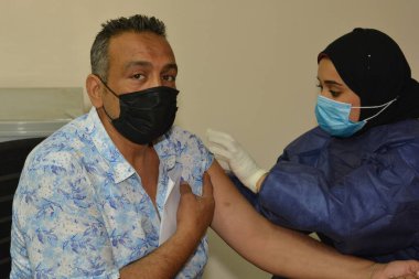 Kahire, Mısır. 31 Ağustos 2021: Kişiye koronavirüs aşısı, COVID-2019 aşısı, salgın hastalığa karşı aşı, Coronavirus aşısı, Covid-19 aşısı, virüsü kontrol altına almak için