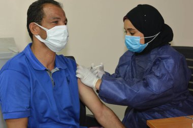 Kahire, Mısır. 31 Ağustos 2021: Kişiye koronavirüs aşısı, COVID-2019 aşısı, salgın hastalığa karşı aşı, Coronavirus aşısı, Covid-19 aşısı, virüsü kontrol altına almak için