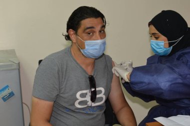 Kahire, Mısır. 31 Ağustos 2021: Kişiye koronavirüs aşısı, COVID-2019 aşısı, salgın hastalığa karşı aşı, Coronavirus aşısı, Covid-19 aşısı, virüsü kontrol altına almak için