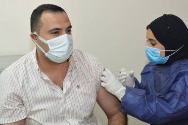 Kahire, Mısır. 31 Ağustos 2021: Kişiye koronavirüs aşısı, COVID-2019 aşısı, salgın hastalığa karşı aşı, Coronavirus aşısı, Covid-19 aşısı, virüsü kontrol altına almak için